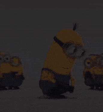a group of minions are standing next to each other and dancing .