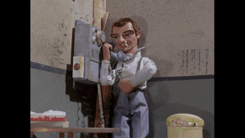 a cartoon man is talking on a pay phone