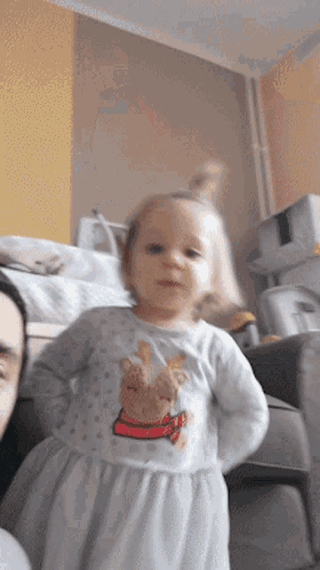 a little girl with a reindeer shirt on