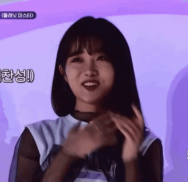 a girl with a purple background is making a funny face