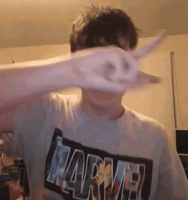 a man wearing a marvel t-shirt covering his face