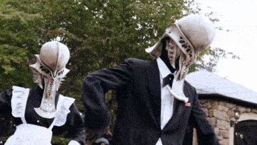 a man in a tuxedo and a woman in a maid outfit are dancing