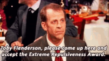 a man in a suit and tie says " by flenderson please come up here and accept the extreme repulsion award "