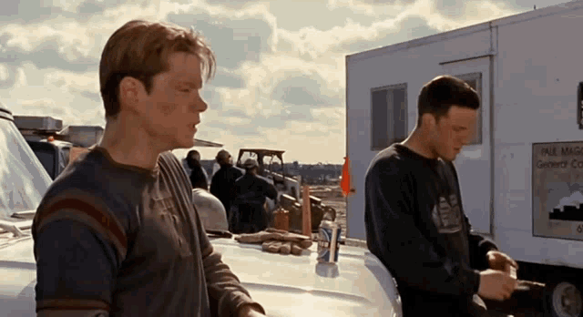two men are standing in front of a trailer that says valley magna