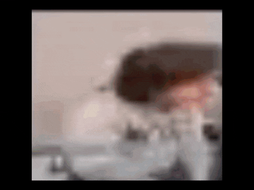 a blurry picture of a person 's face with a bottle of water in the background .