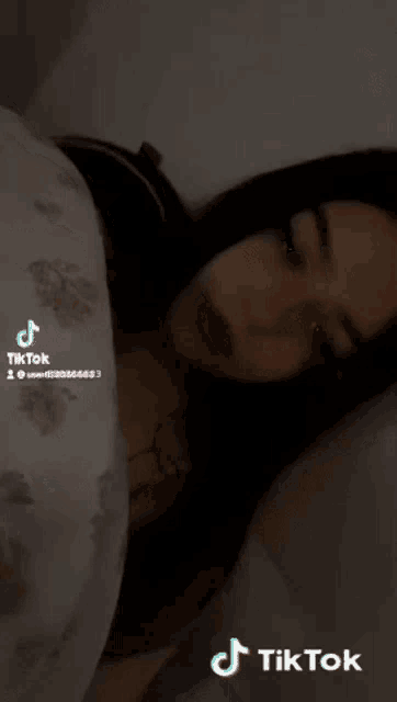 a woman is laying in bed with a tiktok watermark on the bottom