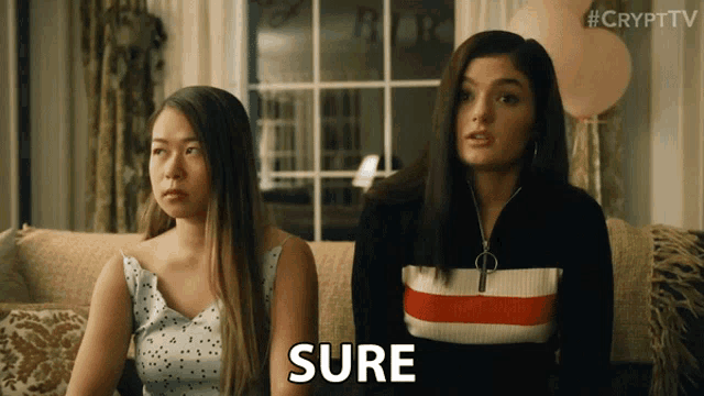 two women are sitting on a couch and the word sure is on the screen