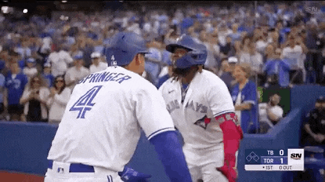 two baseball players are hugging each other on the field .