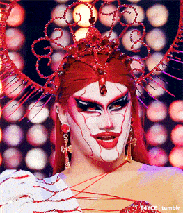 a drag queen with red hair and a crown
