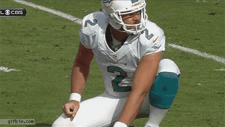 a miami dolphins football player is squatting down on the field