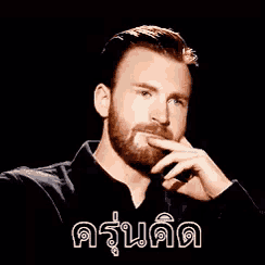 a man with a beard is smoking a cigarette while wearing a black shirt and looking at the camera .