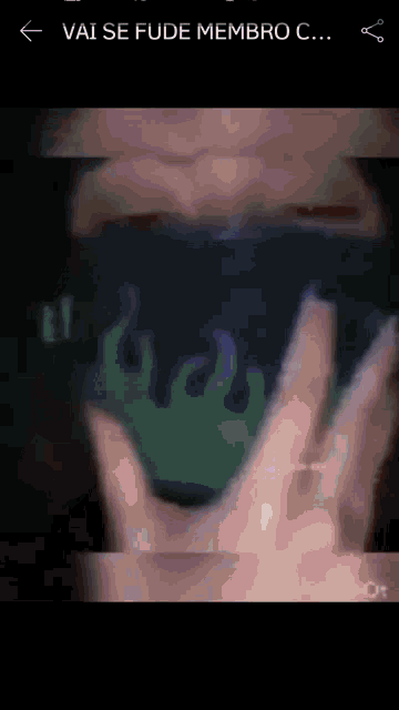 a person is holding a green cup with flames on it