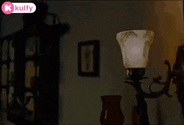 a lamp is sitting on a table in a room with a k kulfy logo in the corner