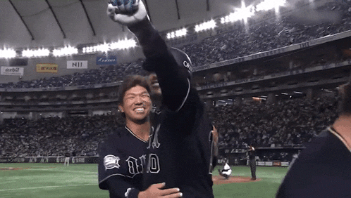 a baseball player wearing a jersey that says ayo holds up his arm