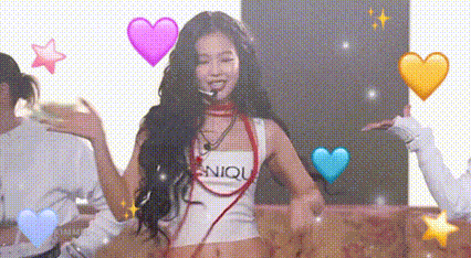 a woman is sitting on a couch in front of a microphone surrounded by hearts .