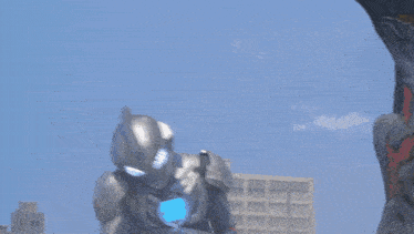 a robot is standing on top of a building while a monster is standing below it