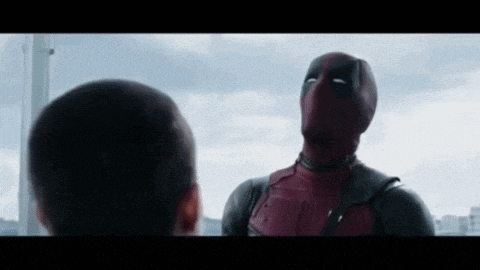 a man in a deadpool costume is standing next to another man in a superhero costume .