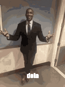 a man in a suit and tie is standing in a hallway with his arms outstretched and the word dob on the bottom right
