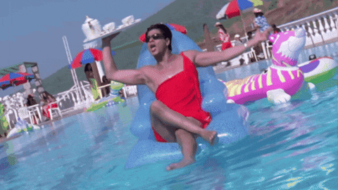 a man in a red bathing suit sits on a raft in a pool