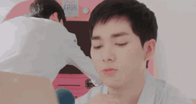 a man making a face in front of a machine that says aron on it
