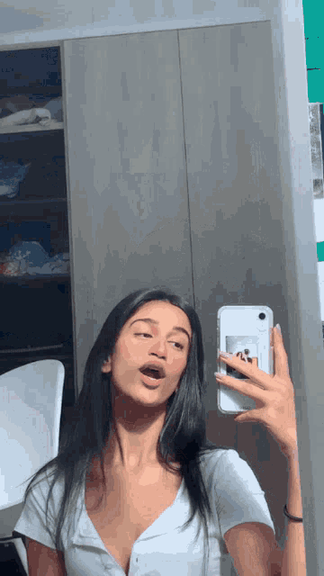a woman taking a picture of herself in the mirror