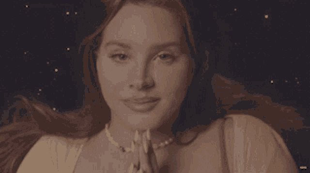 a woman wearing a pearl necklace sticks her tongue out