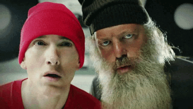 a man wearing a red hat and a man with a beard are looking at each other