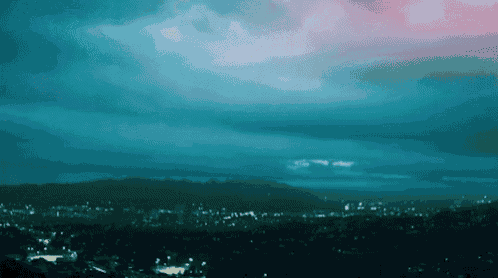a city at night with mountains in the background