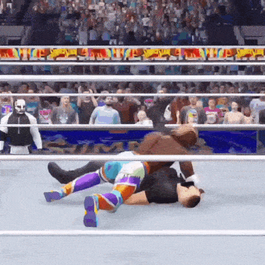 a wrestling match is being played in front of a crowd with a banner that says ' wwe ' on it