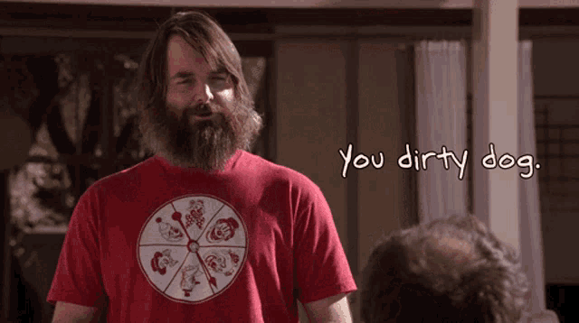 a man with a beard wears a red shirt that says " you dirty dog "