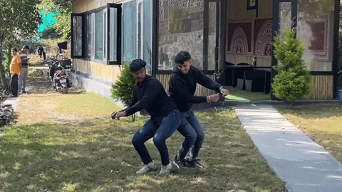 two men are dancing in front of a building that has a sign that says ' a ' on it