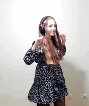 a woman wearing headphones and a black and white dress is dancing