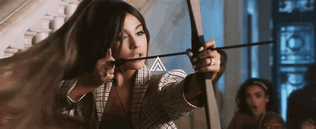 a woman is holding a bow and arrow with the letter a on the bottom