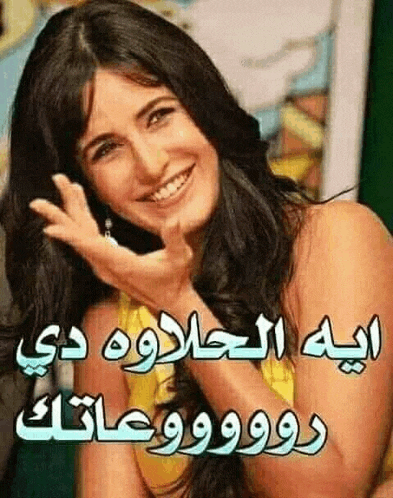 a woman is smiling with arabic writing on her face .