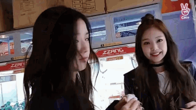 two girls are standing next to each other in front of a machine that says zzanc on it