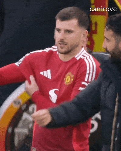 a man in a red shirt is being held by another man .