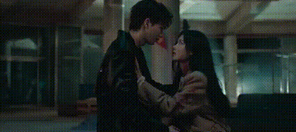 a man and a woman are standing next to each other in a dark room .