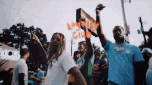 a group of people are dancing in front of a loyalty club sign