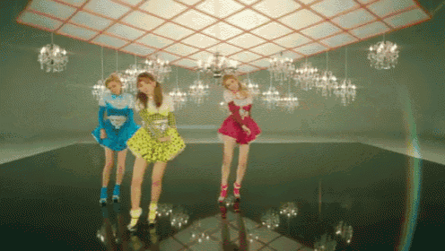 three girls are dancing in a room with many chandeliers
