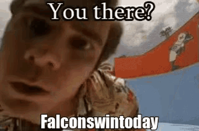 a man in a hawaiian shirt is holding a red flag in front of his face .