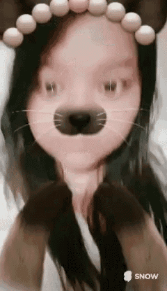 a girl is wearing a cat mask and a headband of beads .