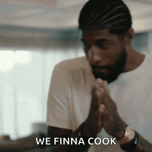 a man with a beard and braids is praying with his hands folded in front of him .