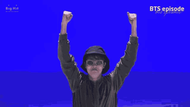 a man wearing a hat and sunglasses giving a thumbs up