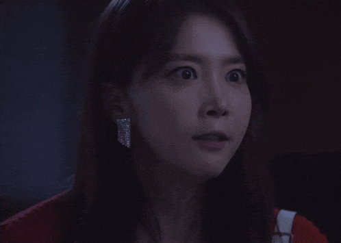 a woman with a surprised look on her face wearing a pair of earrings