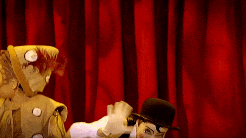 a man in a hat is holding another man 's hand