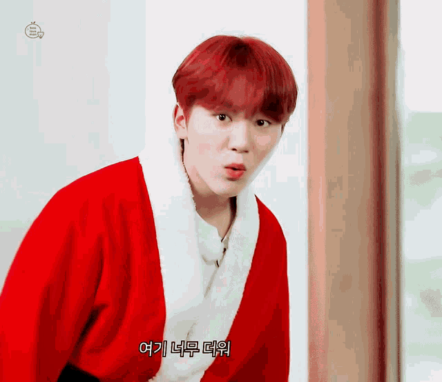 a young man with red hair is wearing a santa claus outfit