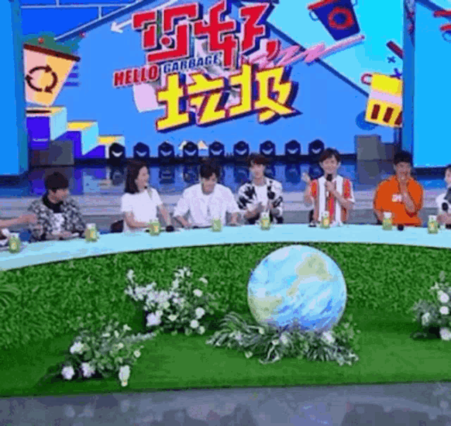 a group of people are sitting around a table with a globe in the middle of the table .
