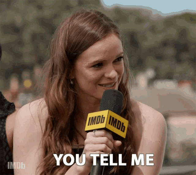 a woman is holding a microphone that says imdb