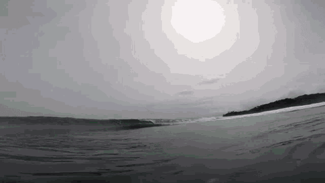 a surfer is riding a wave on a sandy beach .
