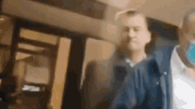 a blurry picture of a man wearing a mask standing in a room .